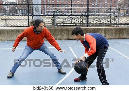 Stock Photograph - Native American father and son playing basketball. Fotosearch