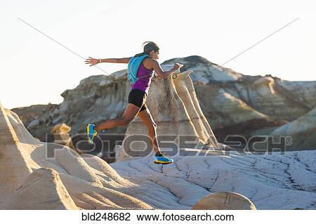 Stock Image - Native American woman running in desert. Fotosearch