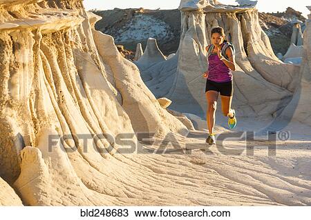 Stock Image - Native American woman running in desert. Fotosearch