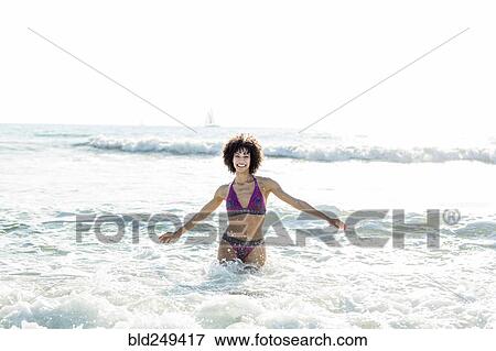 Ocean waves splashing on Mixed Race woman View Large Photo Image Stock Photo - Ocean waves splashing on Mixed Race woman. Fotosearch