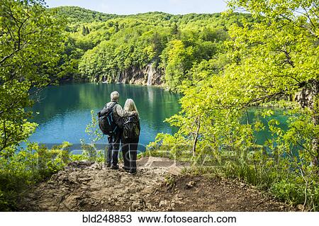 Stock Image - Older Caucasian couple admiring waterfall. Fotosearch
