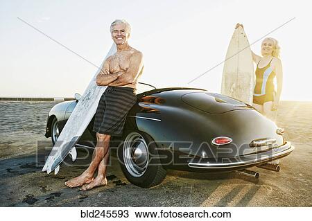 Older Caucasian couple on standing near convertible car with surfboards View Large Photo Image Stock Image - Older Caucasian couple on standing near convertible car with surfboards. Fotosearch