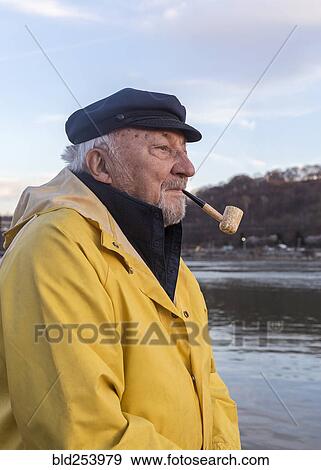 Stock Photo - Older Caucasian fisherman near water. Fotosearch