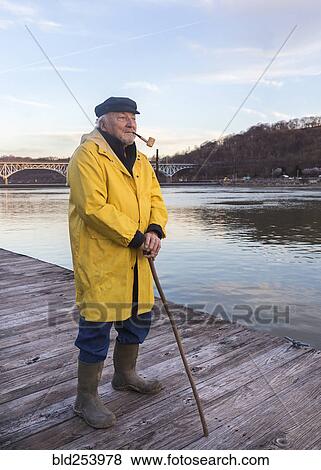 Stock Photo - Older Caucasian fisherman standing on dock. Fotosearch