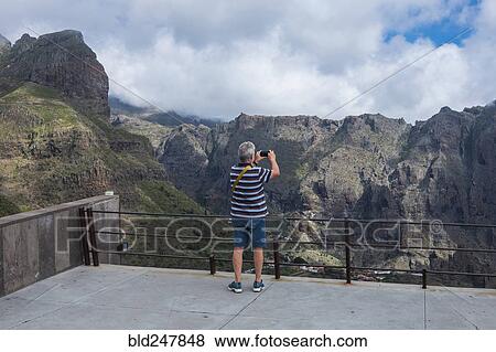 Older Caucasian man photographing mountains with cell phone View Large Photo Image Stock Photo - Older Caucasian man photographing mountains with cell phone. Fotosearch