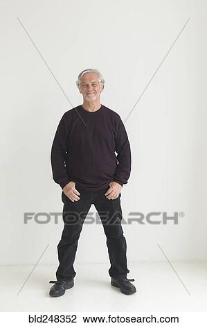 Stock Image - Older Caucasian man with thumbs in pockets. Fotosearch