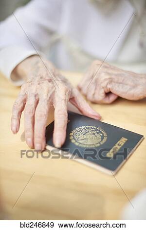 Stock Photo - Older Caucasian woman holding Mexico passport. Fotosearch