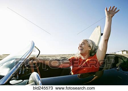 Older Caucasian woman in convertible car with surfboard on beach View Large Photo Image Stock Image - Older Caucasian woman in convertible car with surfboard on beach. Fotosearch