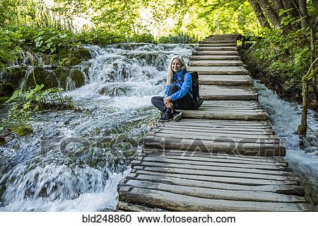 Older Caucasian woman sitting on wooden staircase over waterfalls View Large Photo Image Stock Image - Older Caucasian woman sitting on wooden staircase over waterfalls. Fotosearch