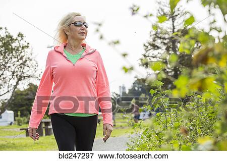 Older Caucasian woman walking in park View Large Photo Image Stock Photo - Older Caucasian woman walking in park. Fotosearch
