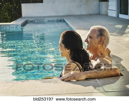 Stock Photo - Older couple relaxing in swimming pool. Fotosearch