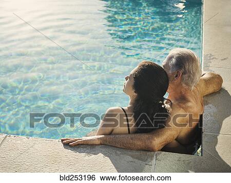 Stock Photograph - Older couple relaxing in swimming pool. Fotosearch