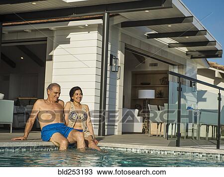 Older couple sitting at the edge of swimming pool View Large Photo Image Stock Image - Older couple sitting at the edge of swimming pool. Fotosearch