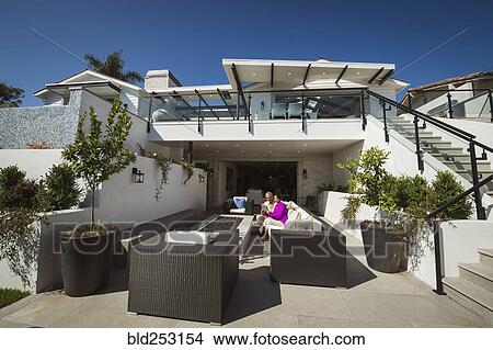 Picture - Older couple using digital tablet on modern backyard patio. Fotosearch
