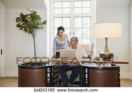 Older couple using laptop in home office View Large Photo Image Stock Photo - Older couple using laptop in home office. Fotosearch