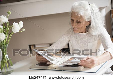 Older woman enjoying photo album View Large Photo Image Stock Image - Older woman enjoying photo album. Fotosearch