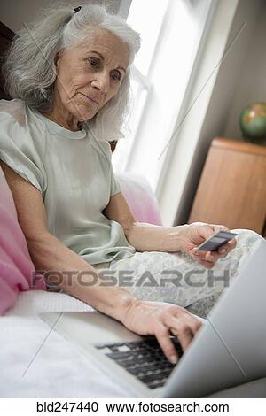 Older woman shopping online with credit card and laptop View Large Photo Image Stock Image - Older woman shopping online with credit card and laptop. Fotosearch