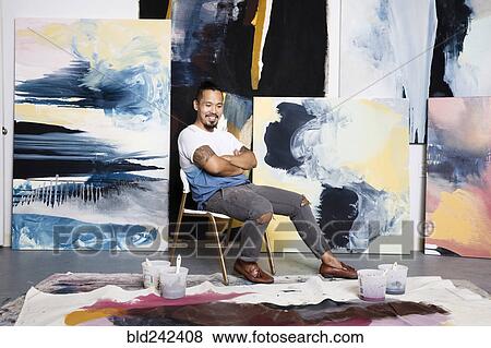 Stock Photo - Pacific Islander painter admiring canvas on floor. Fotosearch