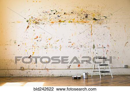 Stock Image - Paint splattered on wall near ladder. Fotosearch