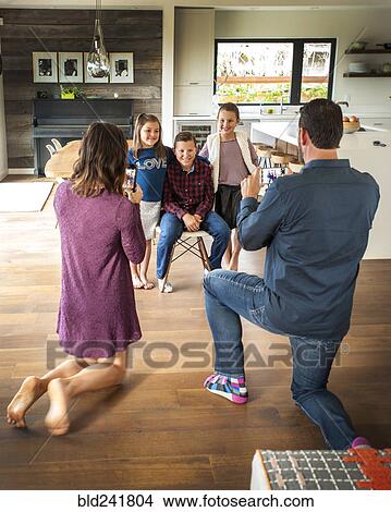 Picture - Parents photographing children with cell phones. Fotosearch