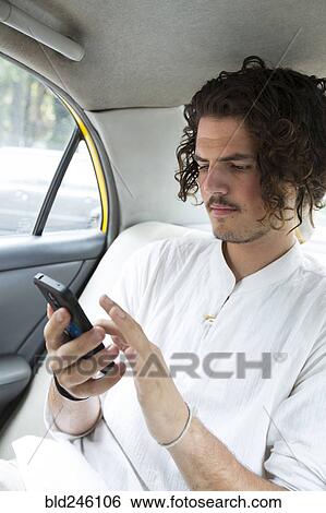 Passenger in car texting on cell phone View Large Photo Image Stock Photograph - Passenger in car texting on cell phone. Fotosearch
