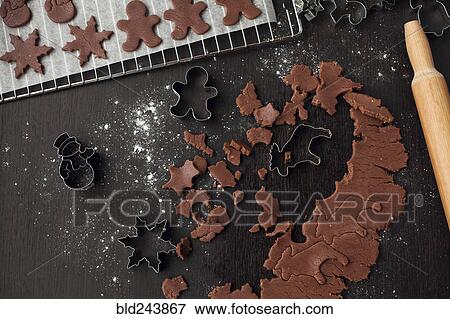 Stock Photo - Pastry cutters and gingerbread dough near rolling pin. Fotosearch