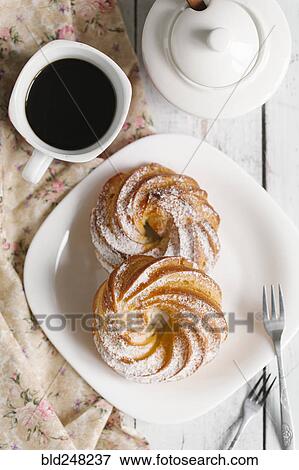 Pastry with powdered sugar on plate with coffee View Large Photo Image Stock Photo - Pastry with powdered sugar on plate with coffee. Fotosearch