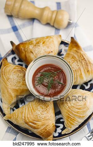 Stock Photography - Pastry with sesame seeds on plate with sauce. Fotosearch