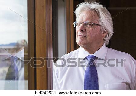 Stock Image - Pensive Caucasian businessman near window. Fotosearch