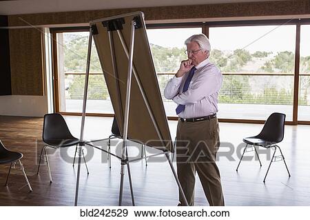Stock Photo - Pensive Caucasian businessman standing near whiteboard. Fotosearch