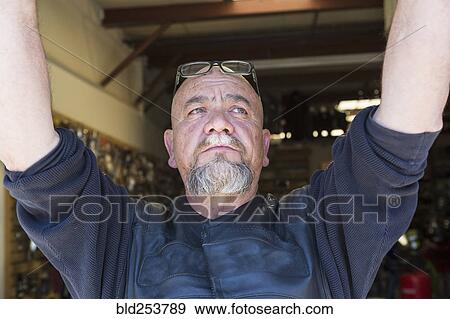 Stock Photo - Pensive Caucasian man with arms raised. Fotosearch