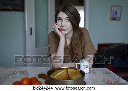 Pensive Caucasian woman sitting at table View Large Photo Image Picture - Pensive Caucasian woman sitting at table. Fotosearch