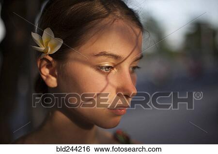 Stock Photograph - Pensive Caucasian woman with flower in hair. Fotosearch