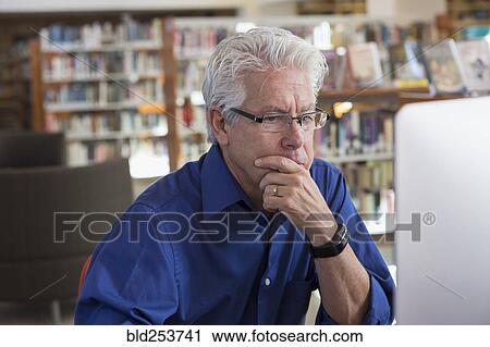 Pensive Hispanic man using computer in library View Large Photo Image Stock Image - Pensive Hispanic man using computer in library. Fotosearch