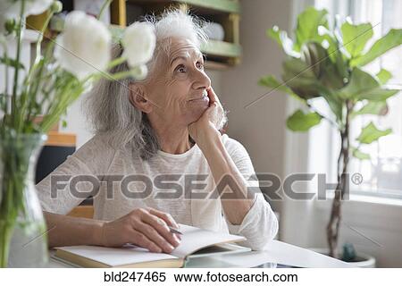 Pensive older woman writing in journal View Large Photo Image Stock Photography - Pensive older woman writing in journal. Fotosearch