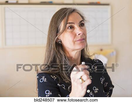 Stock Photo - Pensive teacher holding chalk. Fotosearch