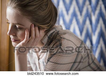 Stock Image - Pensive woman with hand on chin. Fotosearch