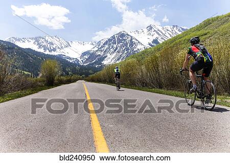 People bicycling on road to mountain View Large Photo Image Stock Image - People bicycling on road to mountain. Fotosearch