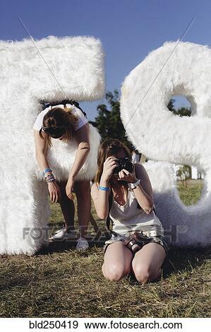 Stock Photo - People photographing near furry letter and number. Fotosearch
