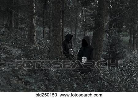 People wearing black robes and holding white masks sitting in forest View Large Photo Image Stock Image - People wearing black robes and holding white masks sitting in forest. Fotosearch