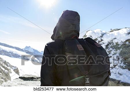 Stock Photo - Person wearing backpack in winter landscape. Fotosearch