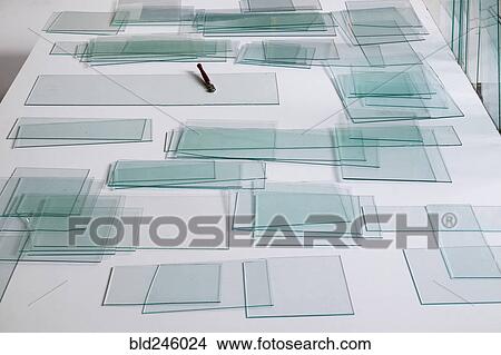 Piles of glass and glass cutter on white table View Large Photo Image Picture - Piles of glass and glass cutter on white table. Fotosearch