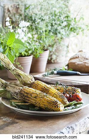 Picture - "Plate of grilled corn, tomatoes and zucchini". Fotosearch