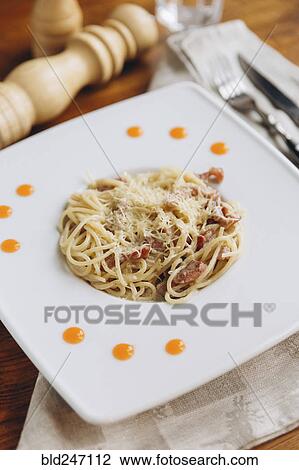 Stock Image - Plate of pasta on table. Fotosearch