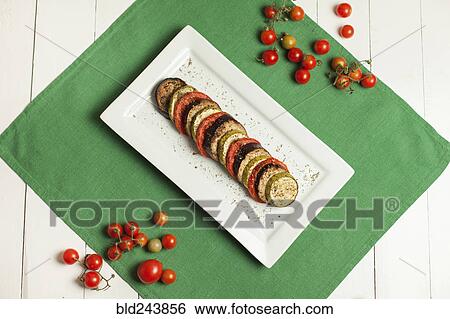 Plate of sliced food and tomatoes on plate and green linen View Large Photo Image Stock Photograph - Plate of sliced food and tomatoes on plate and green linen. Fotosearch
