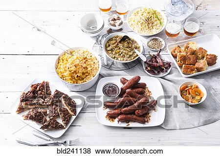 Stock Photo - Plates of food and beer on wooden table. Fotosearch