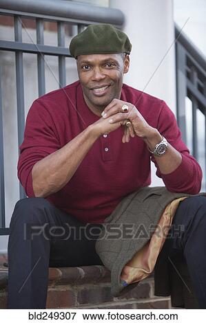 Stock Photo - Portrait of African American man sitting on stoop. Fotosearch