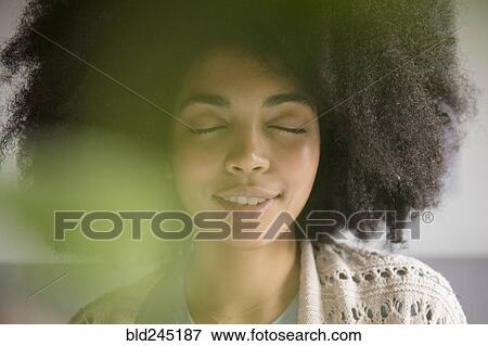 Stock Photo - Portrait of African American woman with eyes closed. Fotosearch