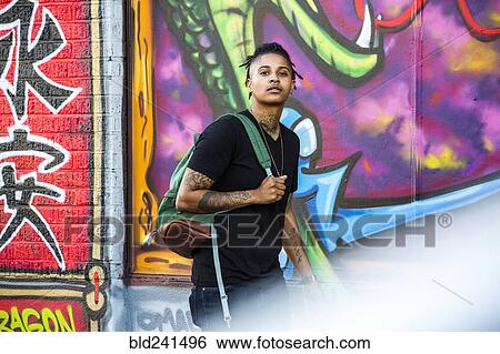 Portrait of androgynous Mixed Race woman near graffiti wall View Large Photo Image Stock Photograph - Portrait of androgynous Mixed Race woman near graffiti wall. Fotosearch