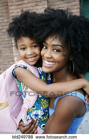 Portrait of Black mother carrying daughter View Large Photo Image Stock Photo - Portrait of Black mother carrying daughter. Fotosearch